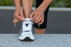 tying-laces-closeup-female-hands-running-shoes-wall-training